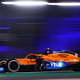 A photo of a McLaren Formula 1 car racing at night.